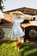Model wearing the Sophia Powder Blue Garden Dress with puff sleeves and a cinched waist